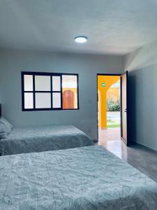 a bedroom with two beds and a yellow door at Hotel Villa Chucum-Tikuch in Tikuch