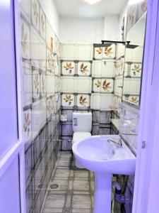 a bathroom with a toilet and a sink at Clara's Beach Inn in Trincomalee +82 photos