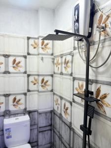 a bathroom with a toilet and a hair dryer at Clara's Beach Inn in Trincomalee