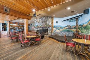 a restaurant with tables and chairs and a fireplace at Cambria Pines Lodge in Cambria