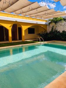 a large swimming pool with an umbrella over it at Hotel Villa Chucum-Tikuch in Tikuch +1 photo