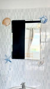a mirror above a sink in a bathroom with seashells at DANK Hotel 420 friendly Patong Phuket in Patong Beach +62 photos