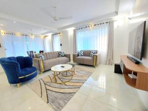 a living room with two couches and a tv at Laxury3BR Mins to Nyali Beach fast WiFi Netflix AC and Free Parking Near wild waters in Mombasa