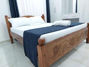 a bed with a blue blanket and white pillows at Laxury3BR Mins to Nyali Beach fast WiFi Netflix AC and Free Parking Near wild waters in Mombasa