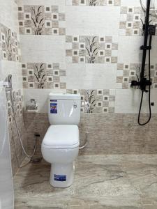 a bathroom with a white toilet in a shower at Clara's Beach Inn in Trincomalee