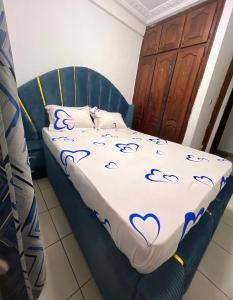 a bedroom with a bed with a blue headboard at Studio meublé akwa in Douala