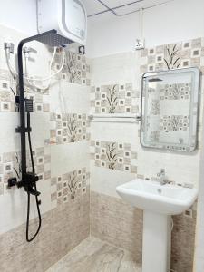 a bathroom with a sink and a mirror at Clara's Beach Inn in Trincomalee