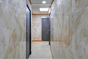 a hallway with a black door and a tile floor at Hotel O Jalan Regency in Kolkata