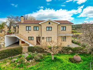 a large stone house with a staircase in a yard at Villa Alonia in Simou
