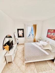a white bedroom with a bed and a desk at Appartamento Moneglia Holidays in Moneglia