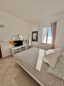 a bedroom with a bed and a mirror and a window at Appartamento Moneglia Holidays in Moneglia