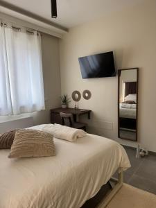 a bedroom with a bed and a mirror and a television at Villa Perla in Battipaglia