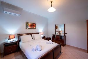 a bedroom with a bed with two lamps and a mirror at Villa Kevin's in Sarandë