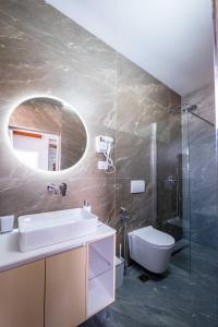 a bathroom with a sink and a toilet and a mirror at Villa Kevin's in Sarandë +49 photos