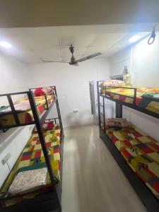 a room with three bunk beds and a ceiling at BEYOND INFINITY GROUP, pg in Navi Mumbai