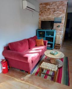 a living room with a red couch and a table at El Trotamundos in Puerto Pirámides