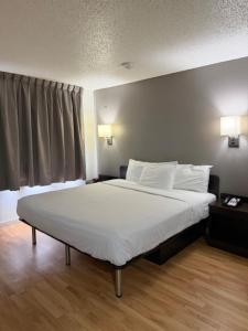 a bedroom with a large bed with white sheets and pillows at Everstay Living in Dallas