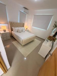 a white bedroom with a bed and a table at Oasis in San Isidro +37 photos