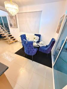 a dining room with blue chairs and a table at Oasis in San Isidro