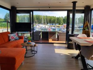 a living room with a couch and a tv and a marina at Floatinghouse Marama - LP10 in Peenemünde