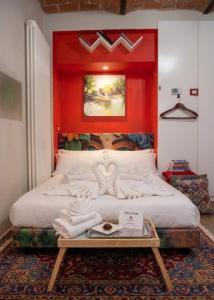 a bedroom with a large bed with a red wall at le voltine in San Damiano dʼAsti