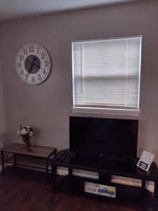a living room with a clock on the wall and a table at The Cocoa Cove in Cocoa