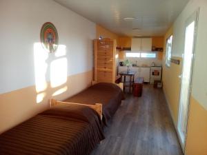 two beds in a small room with a kitchen at Refugio Vegetariano El Mallín - sobre playa in Camarones