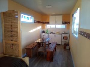 a small kitchen with a wooden table and benches in it at Refugio Vegetariano El Mallín - sobre playa in Camarones