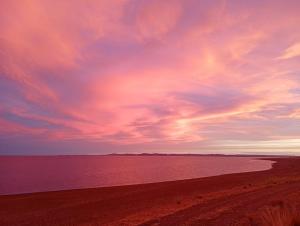 a beach with a cloudy sky and the ocean at Refugio Vegetariano El Mallín - sobre playa in Camarones +11 photos