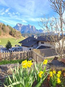 a house with a fence and flowers in the yard at B&B Gasthaus Lieg in Castelrotto