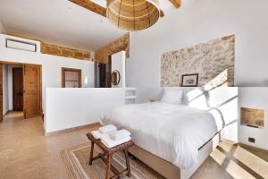 a white bedroom with a large bed and a table at Mansión Santa María in Santa Maria del Camí +32 photos