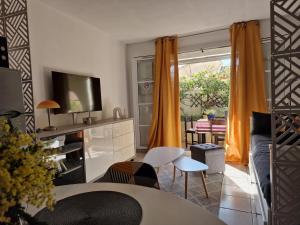 a living room with a couch and a tv at L'oasis bleu in Cerbère