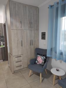 a living room with a chair and a large cabinet at Varkaris Room 3 in Katarráktis
