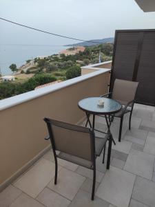 a table and chairs on a balcony with a view of the ocean at Varkaris Room 3 in Katarráktis