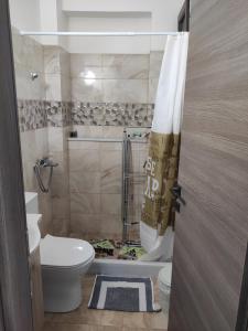a bathroom with a toilet and a shower curtain at Varkaris Room 3 in Katarráktis
