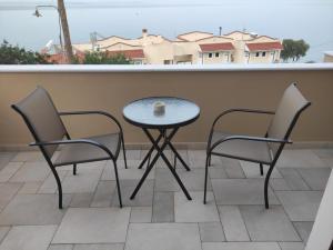 a table and chairs on a balcony with a table at Varkaris Room 3 in Katarráktis +3 photos