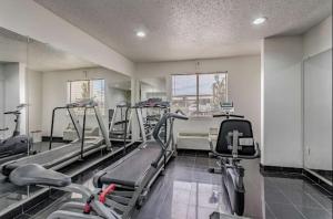 a gym with treadmills and ellipticals in a room at Everstay Living in Dallas