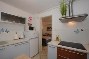 a kitchen with white cabinets and a white refrigerator at Holiday House - Bella Nicol in Koper