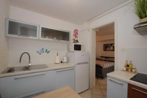 a kitchen with a sink and a refrigerator at Holiday House - Bella Nicol in Koper