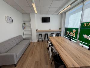 a living room with a couch and a table and a tv at Albergue Porta Real NO BIKE STORAGE in Santiago de Compostela