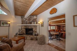 a living room with a stone fireplace and a table at Trailside Escape By Hauserman Rentals in Tahoe City