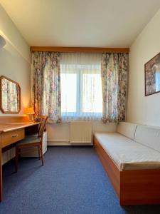 ein Zimmer mit einem Bett, einem Schreibtisch und einem Fenster in der Unterkunft Hotel Astra in Prag