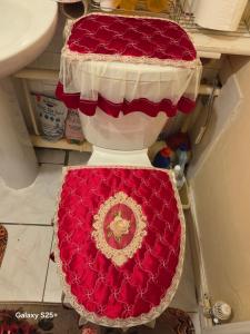 a red and white toilet seat in a bathroom at Kings Rooms in Luton