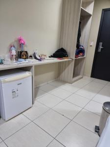 a room with a white tiled floor and a white refrigerator at Kings Rooms in Luton