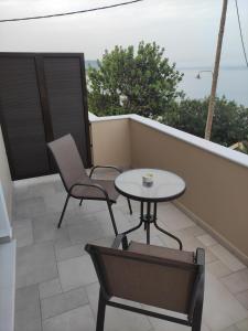 a patio with a table and chairs on a balcony at Varkaris Room 2 in Katarráktis