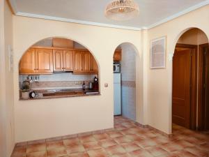 a kitchen with arched ceilings and wooden cabinets at Juweeltje van Hondon, met groot zwembad en rust in Hondón de las Nieves