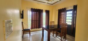 a dining room with a table and two windows at Roca vista villaas vagamon in Vagamon +26 photos