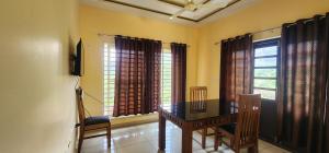 a dining room with a table and a window at Roca vista villaas vagamon in Vagamon