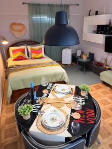a room with a bed and a table with plates of food at Studio Central na Amadora, Vista da Cidade, Sossegado, a 15min de Lisboa in Amadora