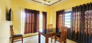a dining room with a table and some windows at Roca vista villaas vagamon in Vagamon